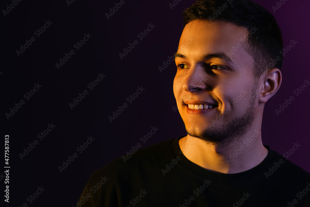 Toned portrait of handsome young man on black background