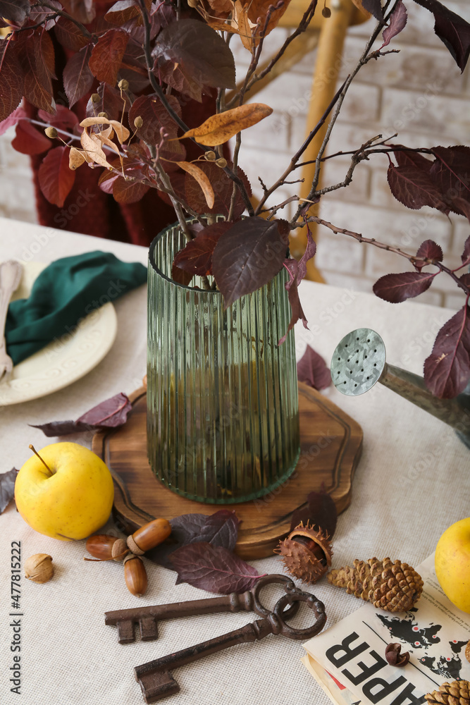 Beautiful composition with vase, metal keys and autumn decor on table, closeup