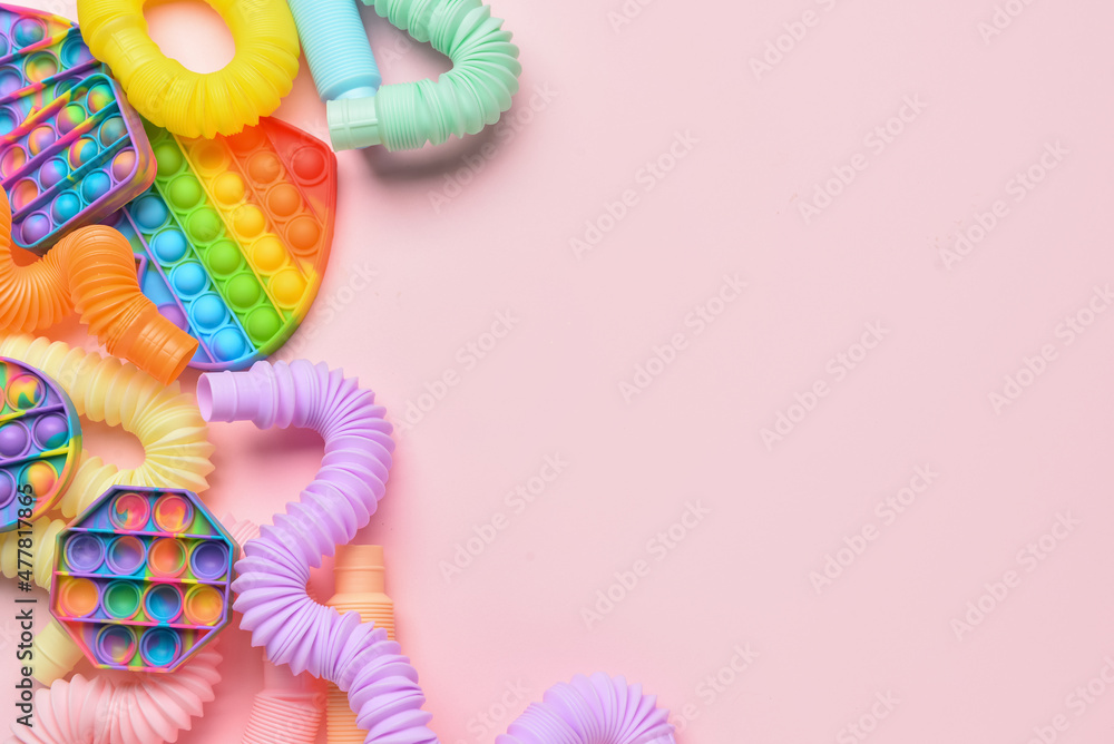 Colorful Pop Tubes and Pop it fidget toys on pink background