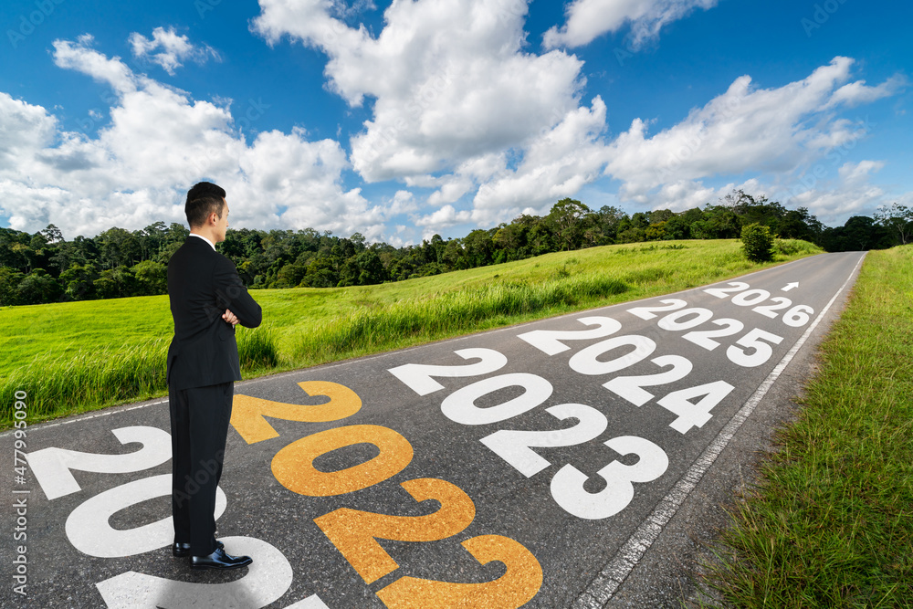 The 2022 New Year journey and future vision concept . Businessman traveling on highway road leading 