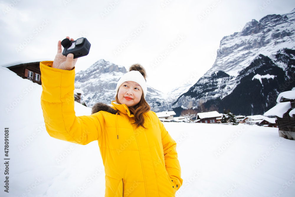 Grindelwald瑞士欧洲之巅，穿着黄色外套的亚洲女性。她在真空吸尘器上感到很开心