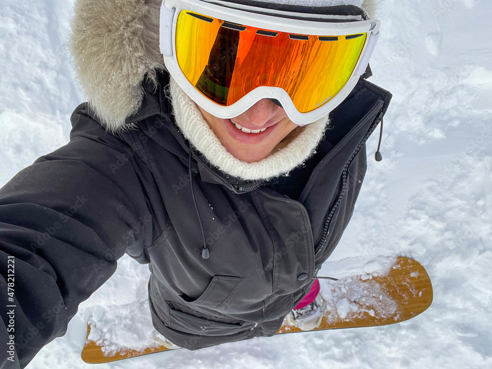 自拍：年轻的高加索女子在阿尔卑斯山滑雪道上微笑。