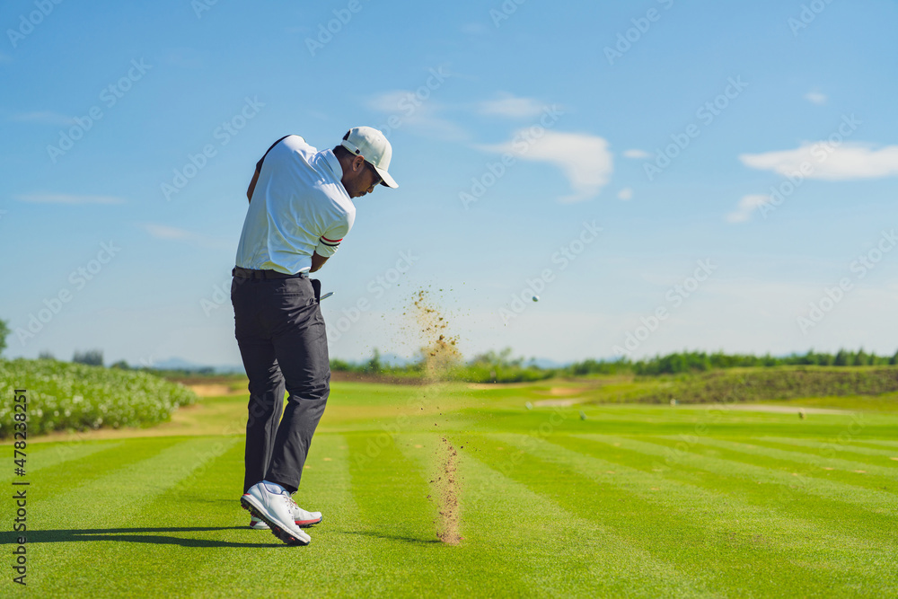 Asian man golfing on the course in summer