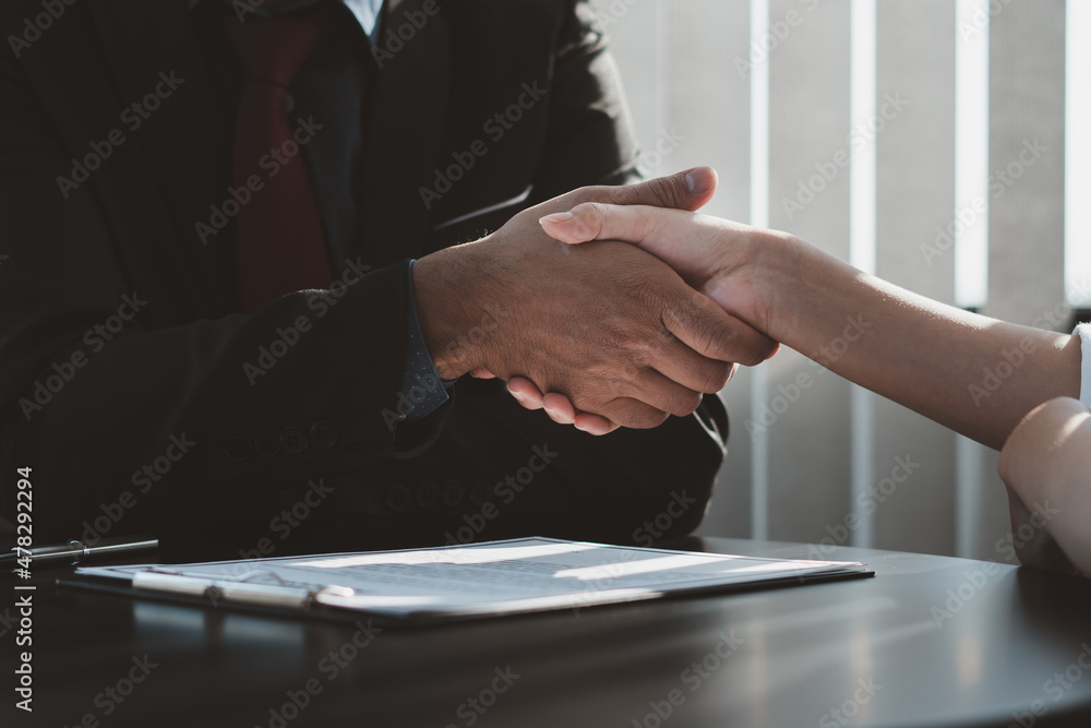 Real estate agent and customers shaking hands together celebrating finished contract after about ins