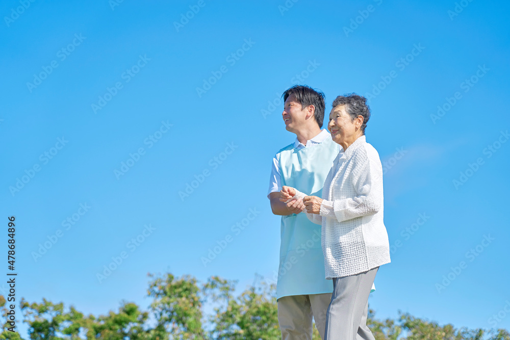 介護士と高齢者　屋外