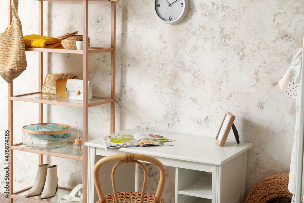 Interior of light room with shelving unit and stylists workplace