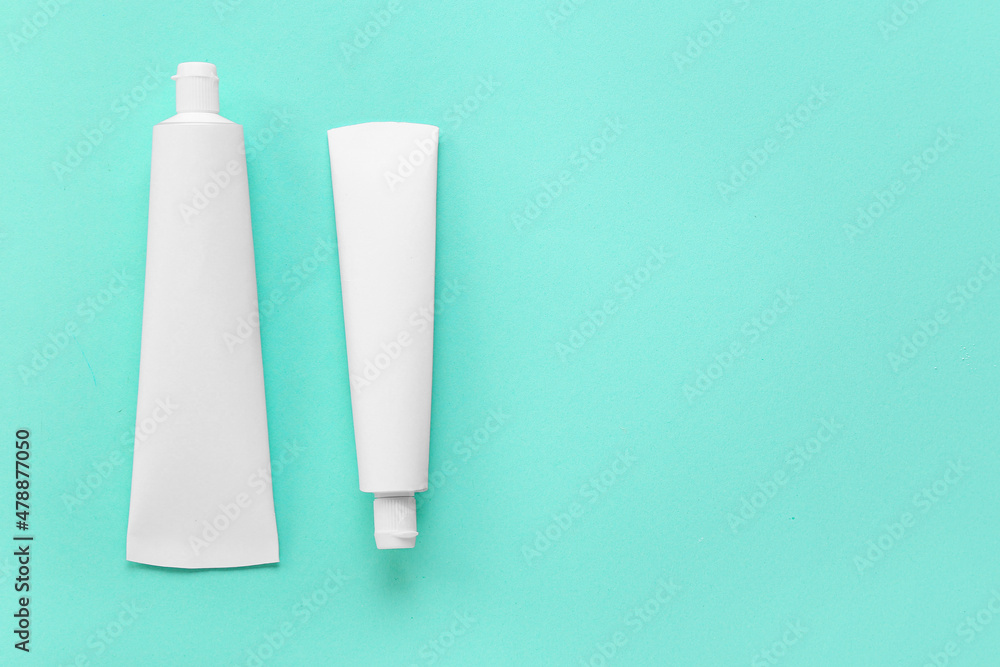 Tubes with tooth paste on color background