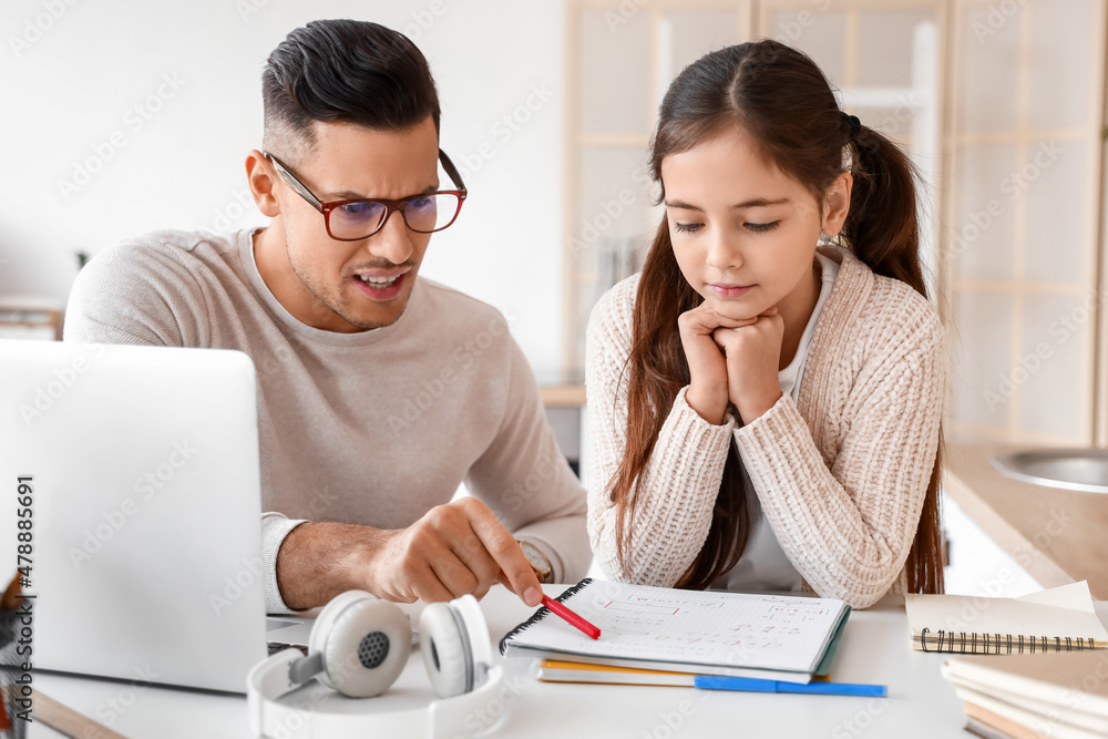 Little girl studying with tutor at home