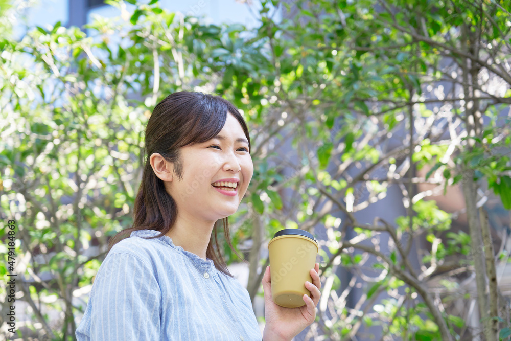 女性　コーヒーを飲む　屋外