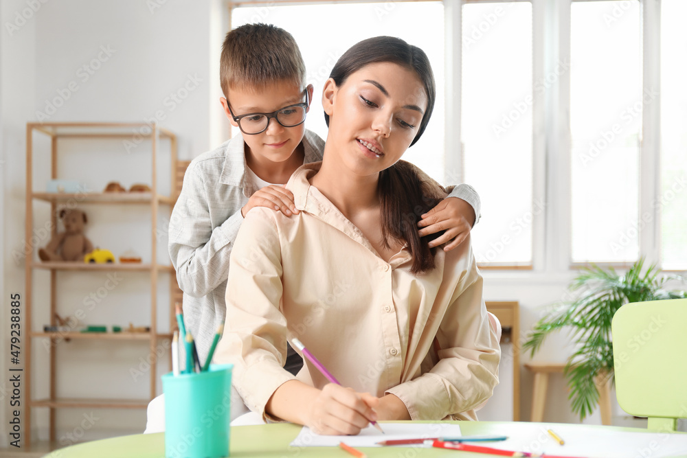 Teenage girl drawing with her little brother at home