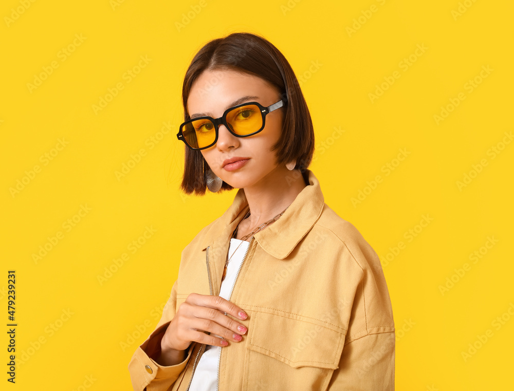 Pretty young woman in stylish clothes on color background