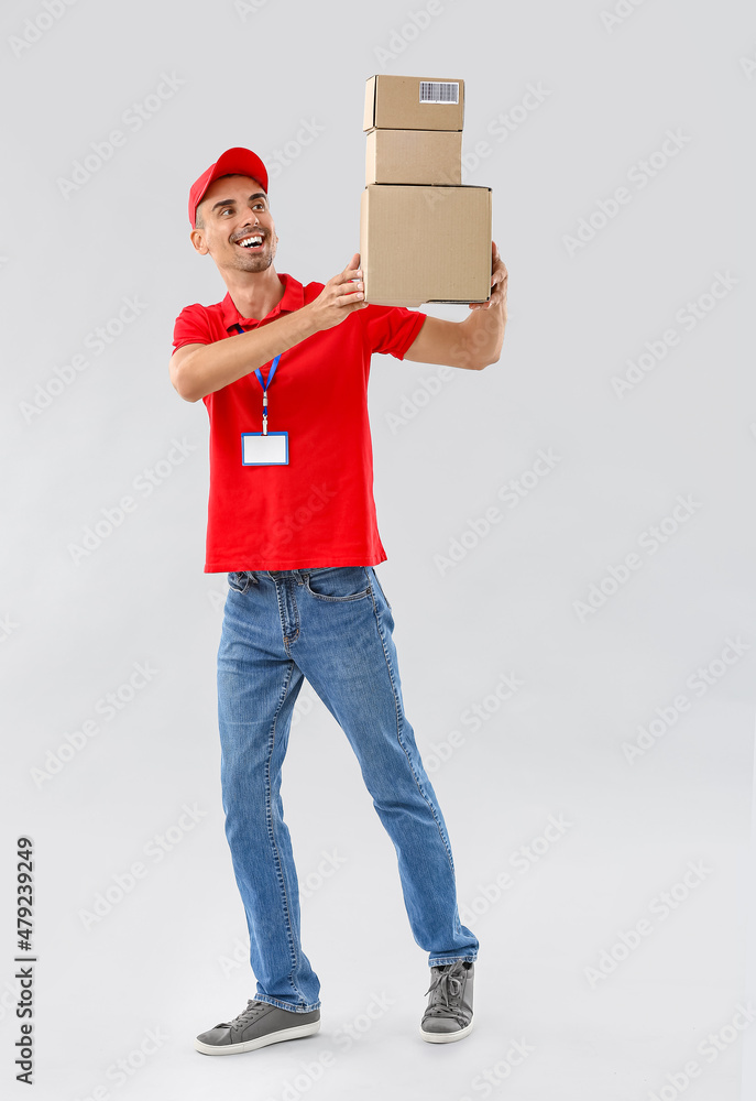 Male courier with parcels on light background