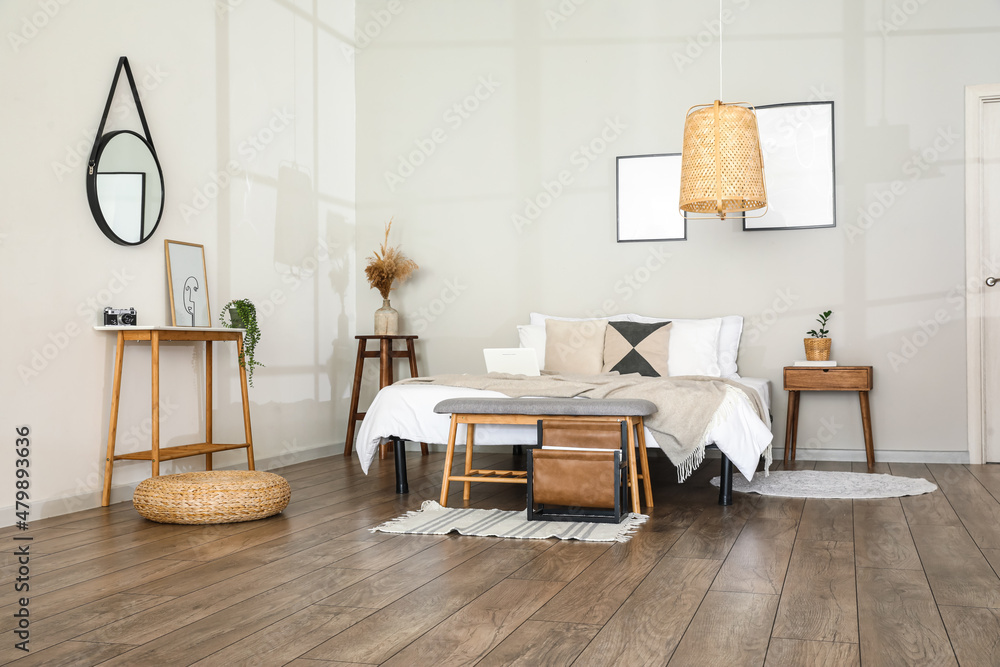 Stylish interior of bedroom with comfortable bed and bench