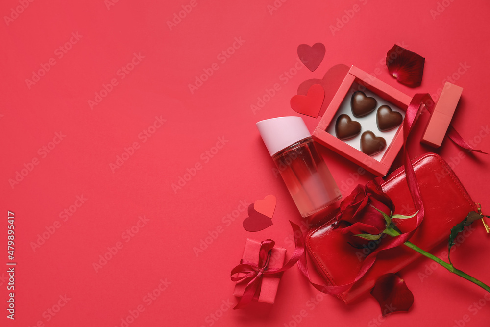 Perfume, rose and chocolate candies for Valentines day on red background