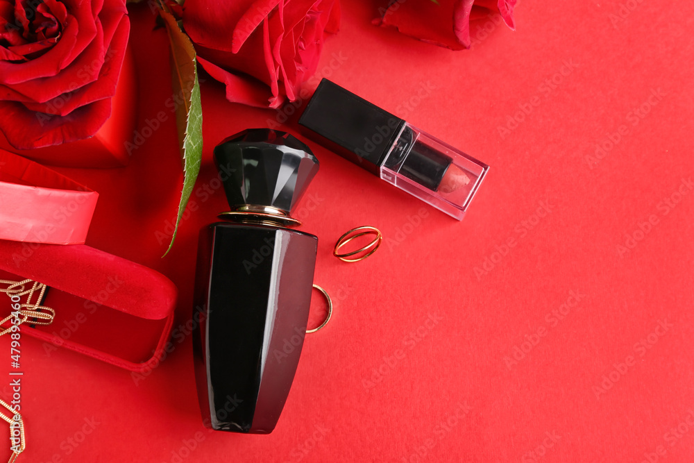 Bottles of perfume and accessories for Valentines day on red background