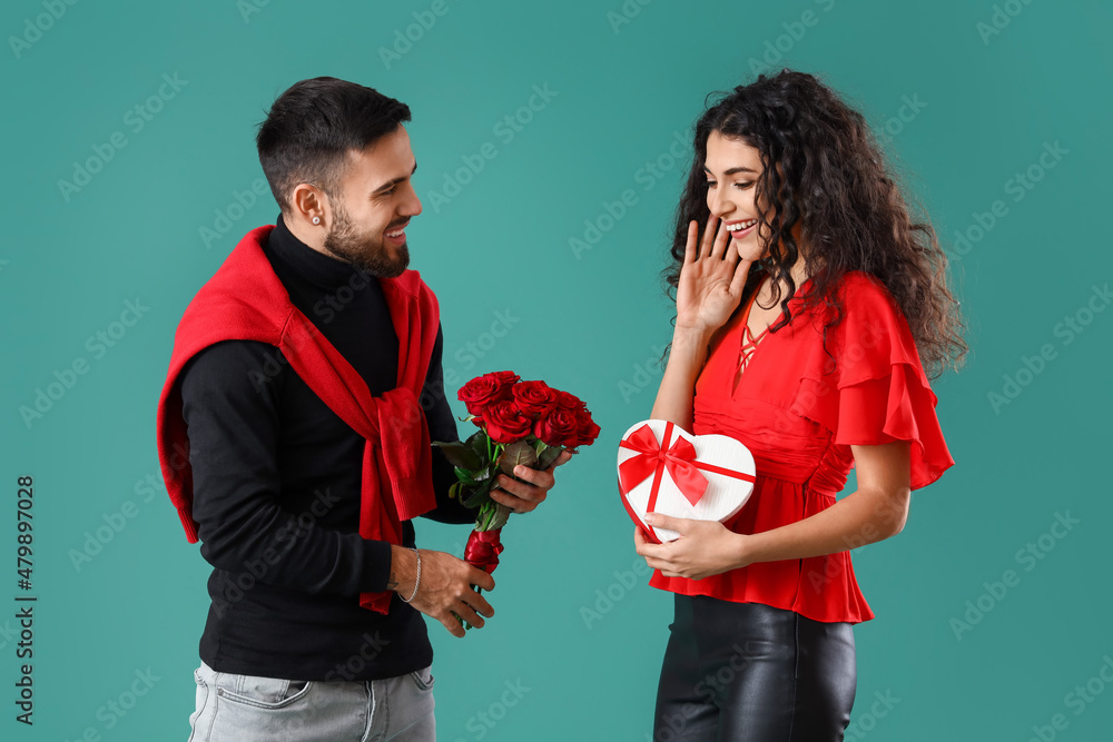 Young man greeting his girlfriend on color  background. Valentines Day celebration