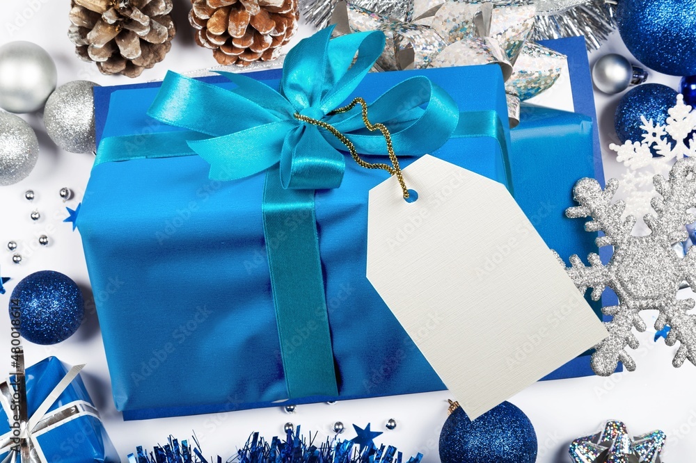 Wrapped Gift Box with a bow on a table with Christmas decorations around. Winter composition