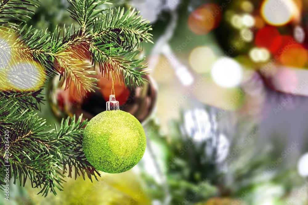 Christmas ball on the Christmas tree surrounded by festive lights.