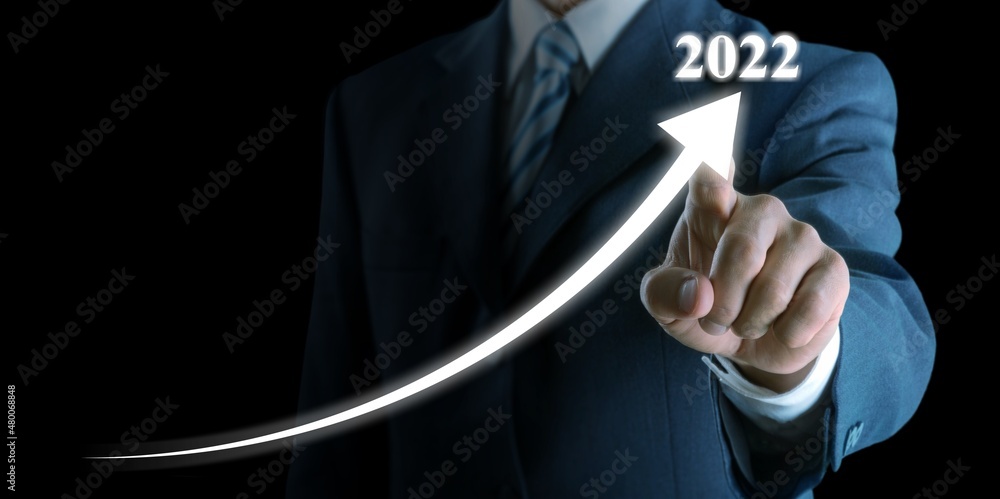 Smart businessman pointing graph future growth plan in 2022 on background.