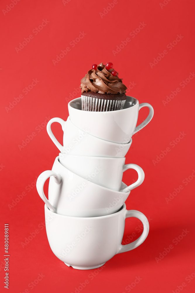 Cups with tasty chocolate cupcake on color background