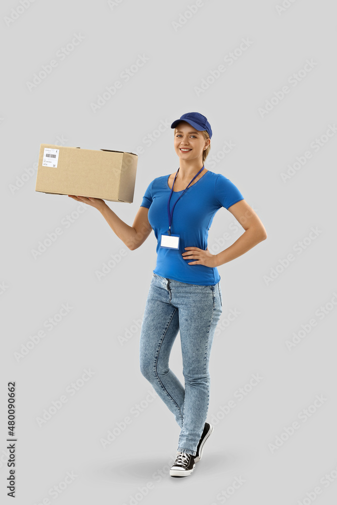 Female courier with parcel on light background