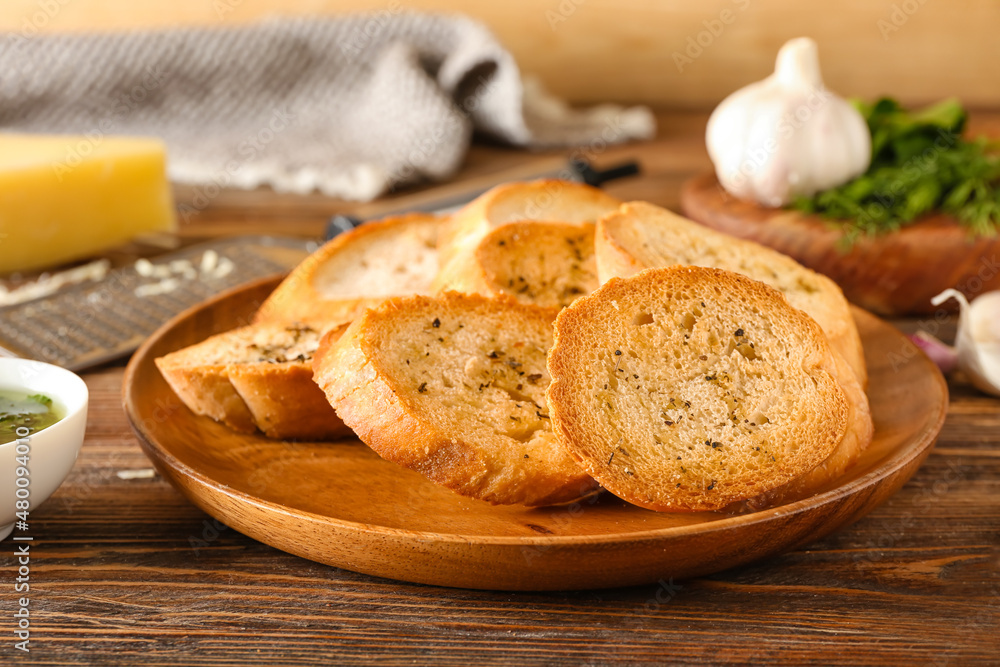 Plate of tasty croutons on table