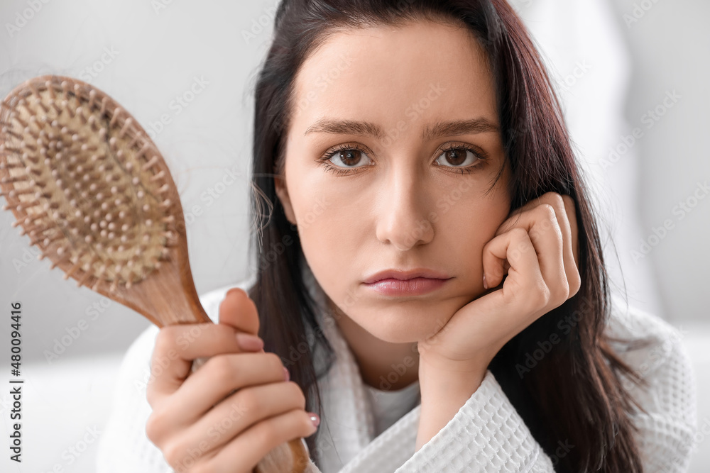 Morning of young woman with hair loss problem at home