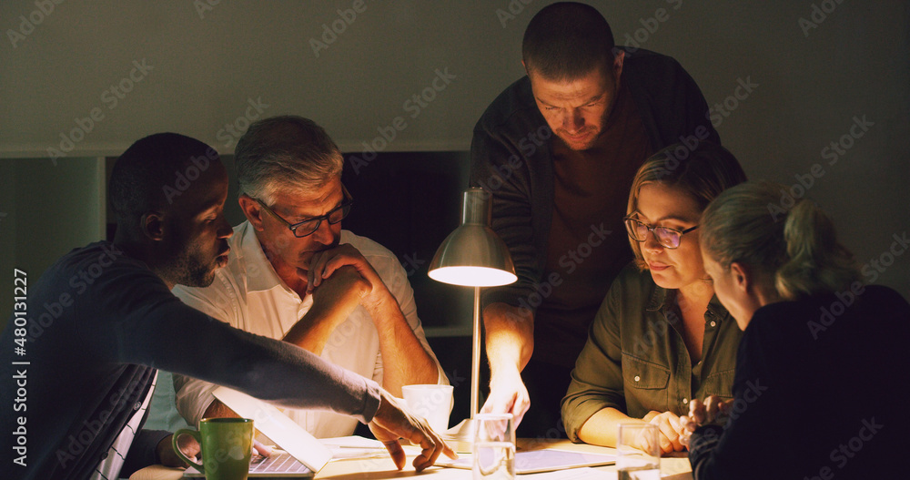 Their deadline is coming up. Cropped shot of a group of businesspeople working together around a tab