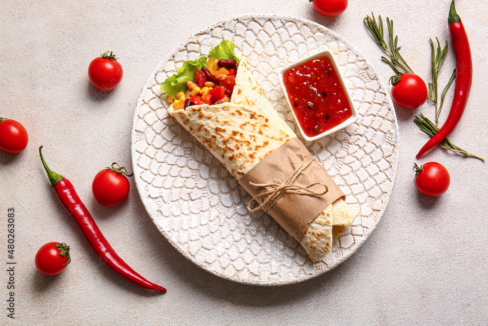 Plate with delicious burrito and sauce on light background