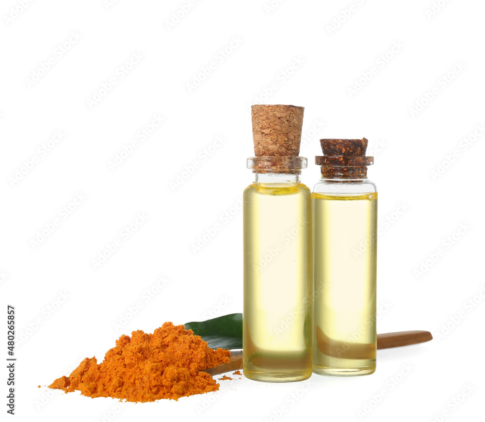 Bottles of oil and turmeric powder on white background