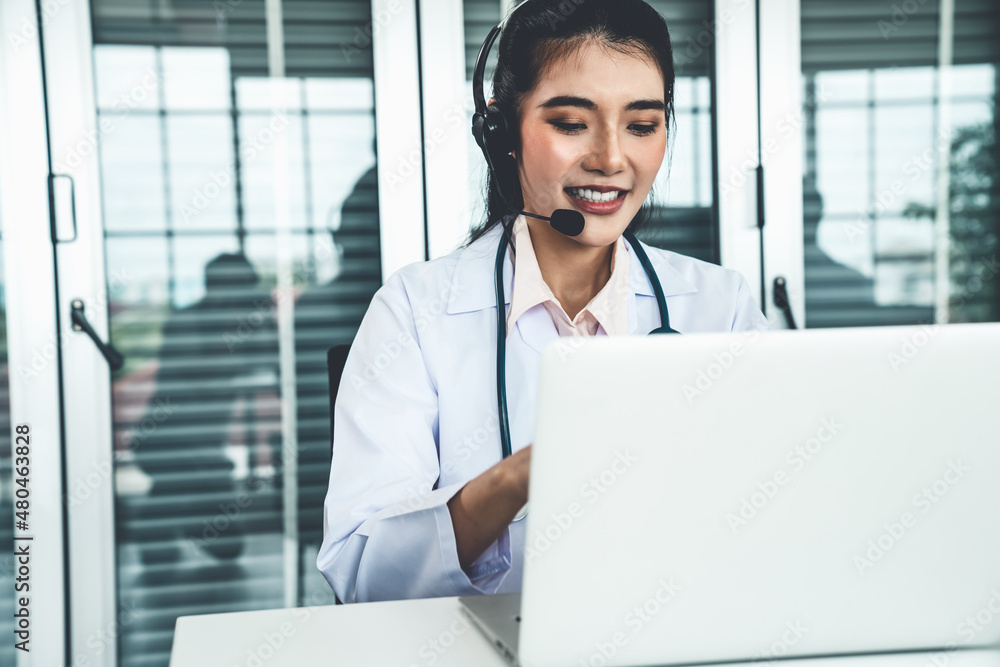 Doctor wearing headset talking actively on video call in hospital or clinic . Concept of telehealth 