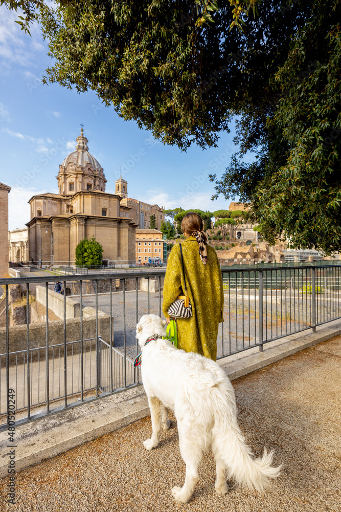 Woman with her dog enjoying view on the Roman forum in the centre of Rome. Concept of italian lifest