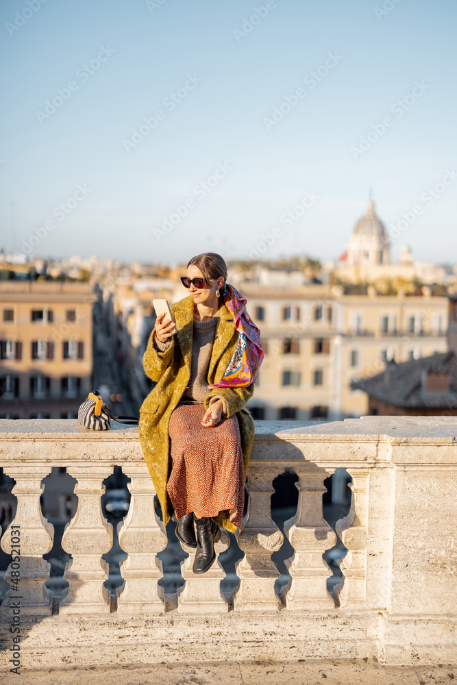 Woman enjoying beautiful morning cityscape of Rome, sitting on the top of famous Spanish steps. Old 