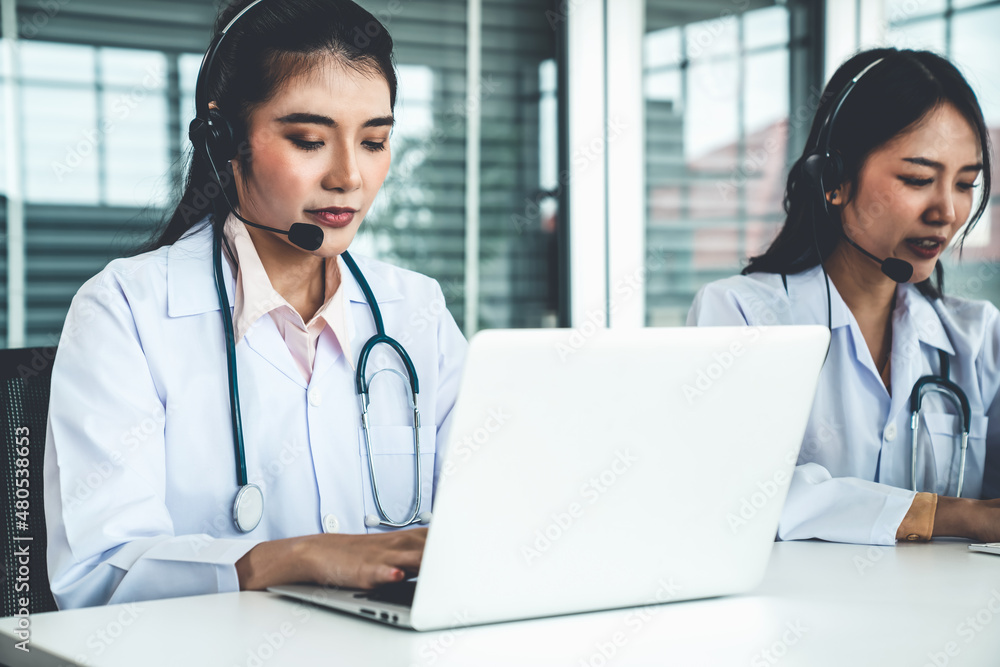 Doctor wearing headset talking actively on video call in hospital or clinic . Concept of telehealth 