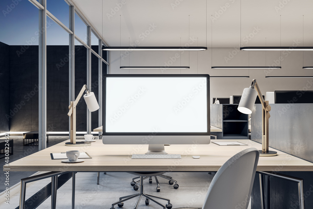 Close up of blank white mock up computer monitor on wooden office desktop in modern interior. Workpl