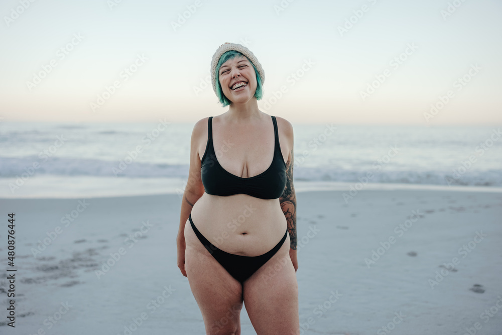 Carefree winter bather smiling with her eyes closed at the beach