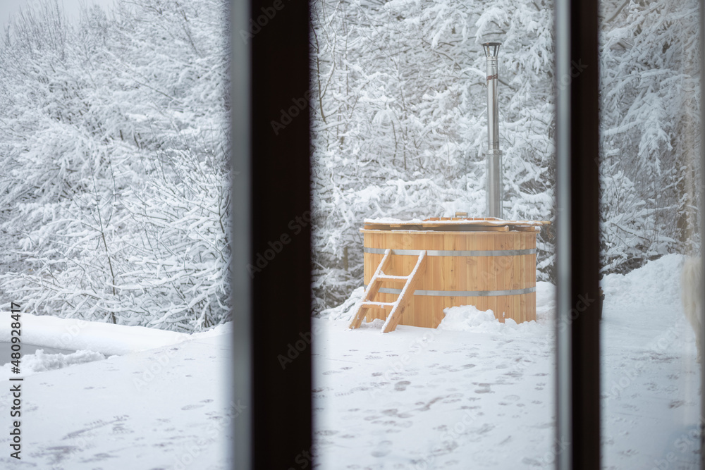 山上雪地露台上的木制热缸。外面有热水浴缸的寒假概念