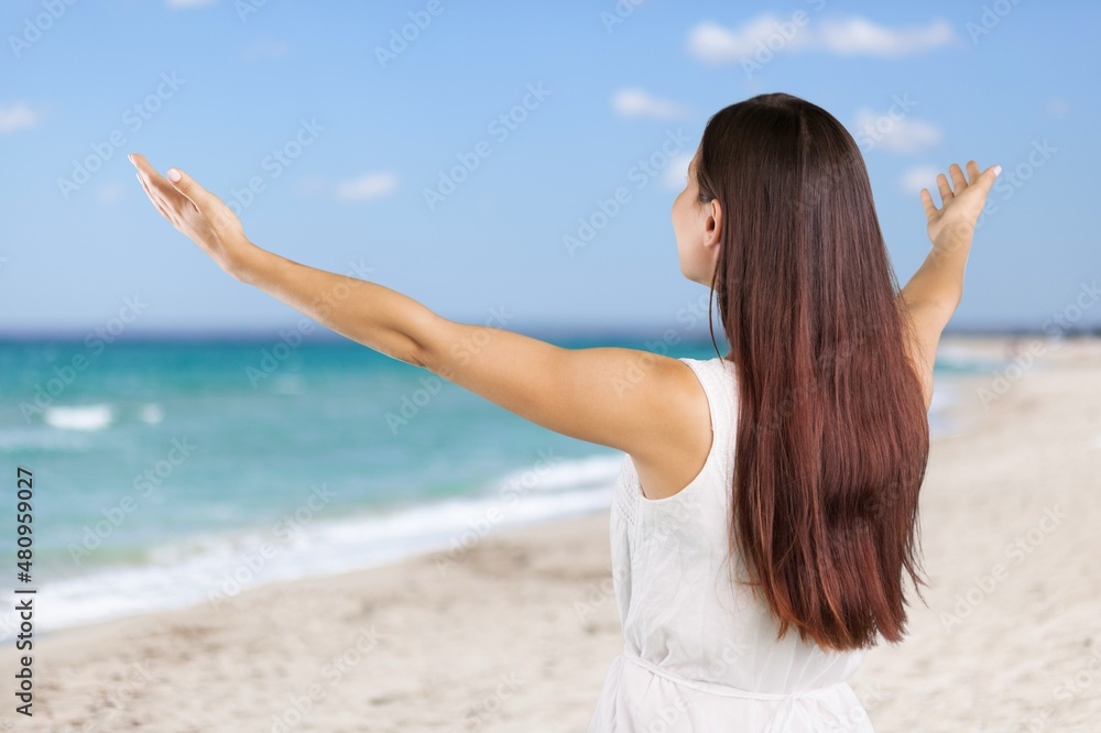 Happy female tourist walks on a sandy beach