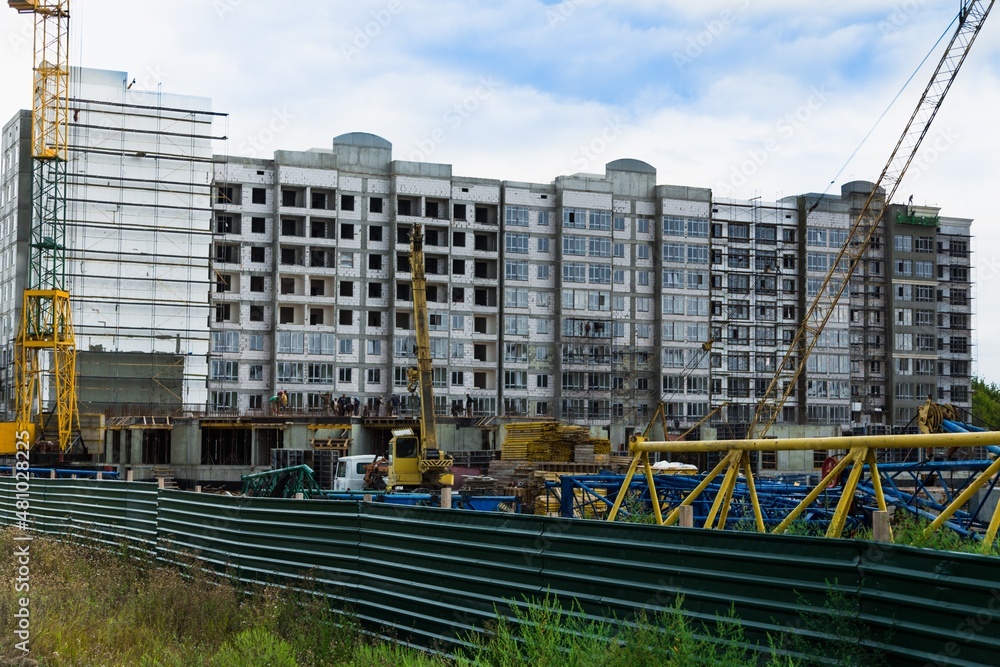 大型建筑工地，包括在建筑群上工作的几台起重机，天空晴朗