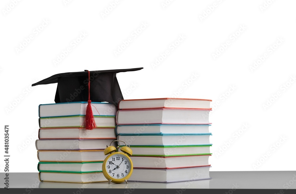 Stack books with black graduation hat