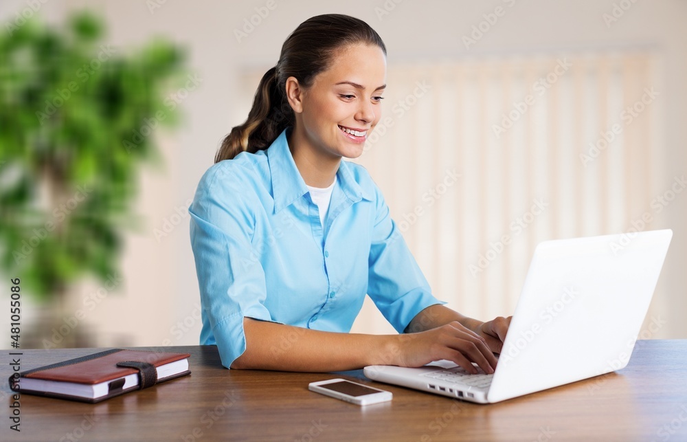 Smiling woman listening educational online lecture, writing notes