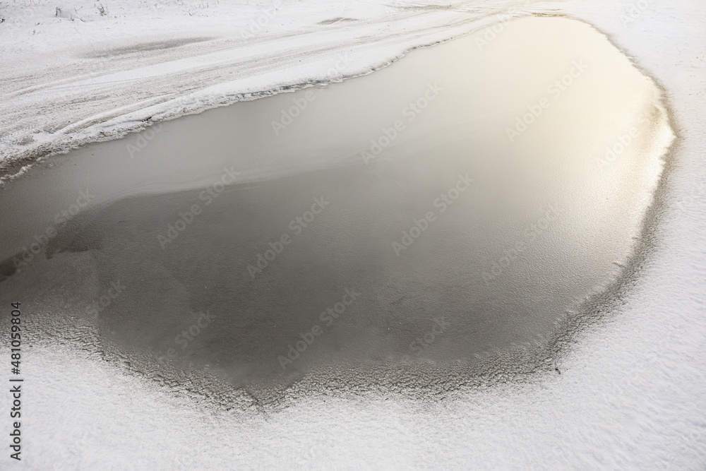 Large puddle of water on snowy road