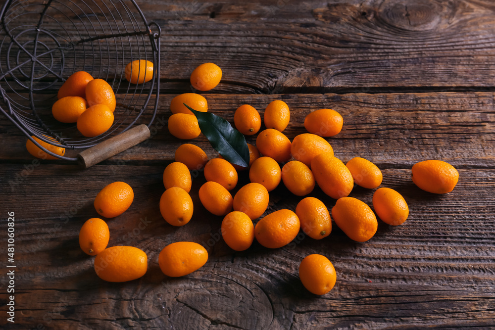 Tasty kumquat fruits on wooden background