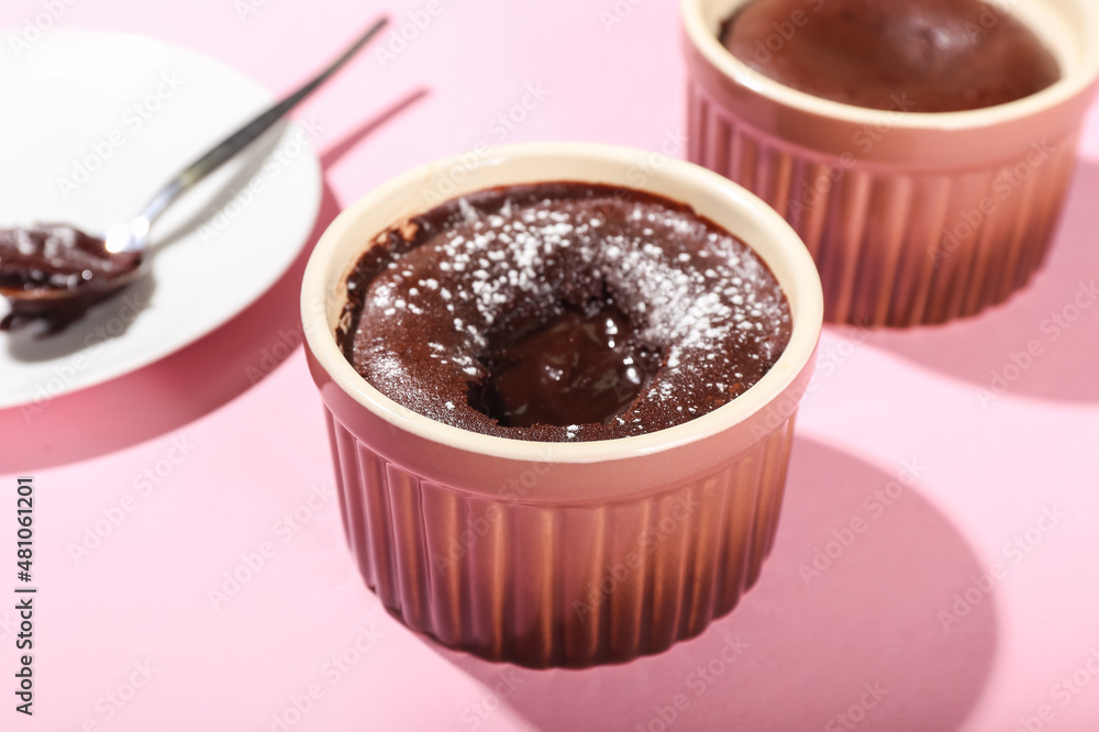 Ramekin with tasty lava cake fondant on pink background, closeup