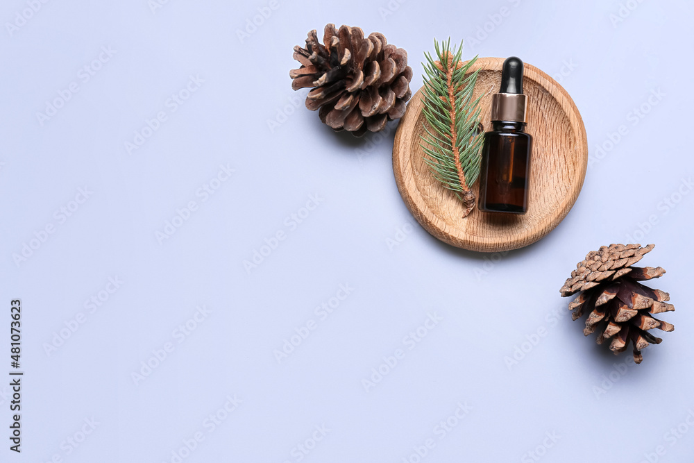 Composition with bottle of essential oil and pine cones on white background