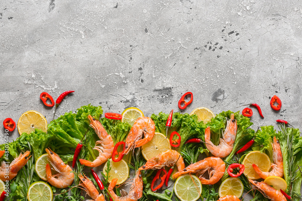 Tasty shrimps with lettuce and lemon on grey background