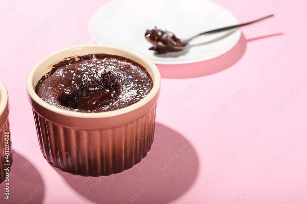 Ramekin with tasty lava cake fondant on pink background, closeup