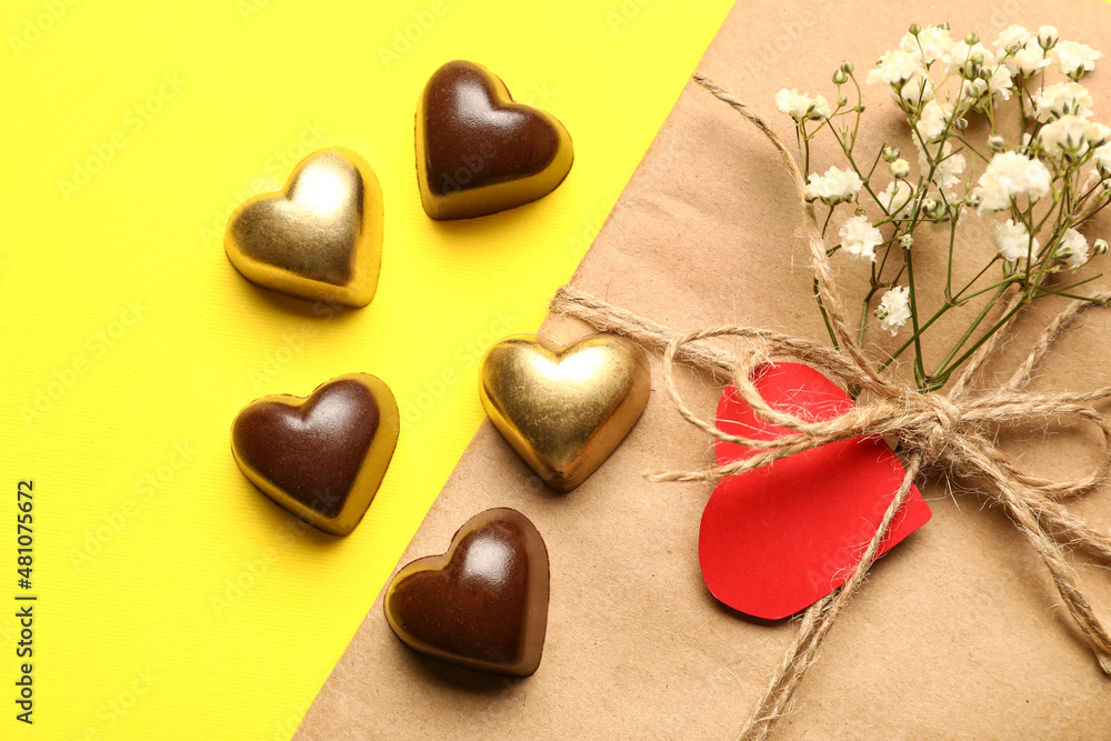 Tasty heart-shaped candies and letter on yellow background