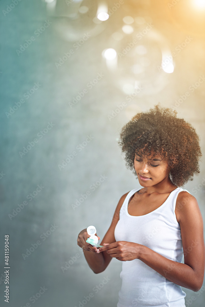 Her morning routine. Cropped shot of a young woman brushing her teeth in the bathroom.