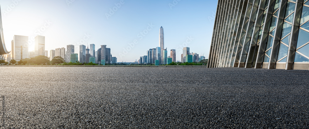 日出时，中国深圳的沥青道路和城市天际线，以及现代化的商业办公楼。